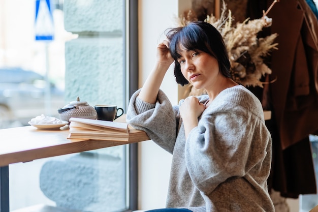 Smiling woman reading book at coffee shop.woman reading book at cafe near window