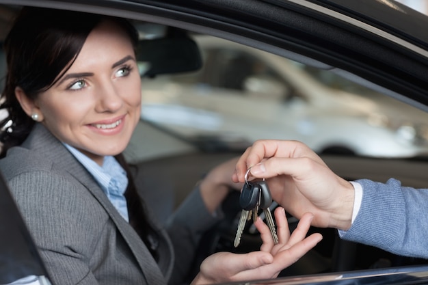 Smiling woman receiving keys from a man