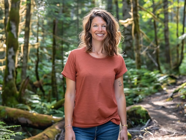 smiling woman in a red shirt standing in a forest