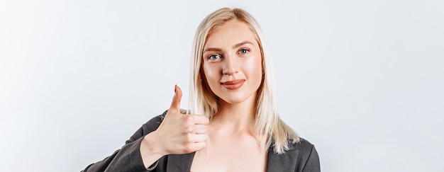 Smiling woman showing thumbs up over white