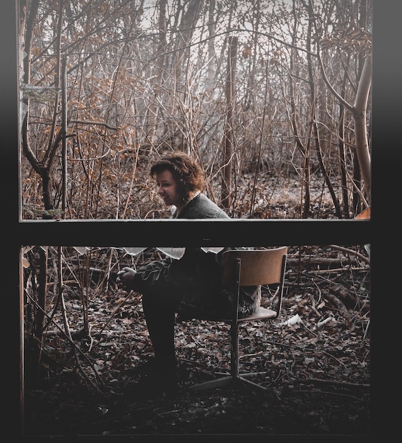 Photo smiling woman sitting on chair in forest