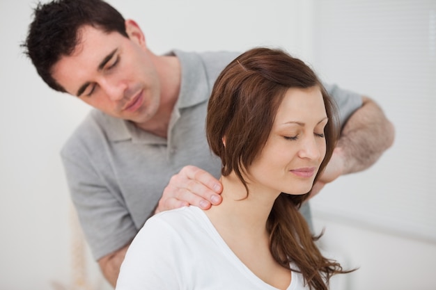 Smiling woman sitting while being massaged by a man