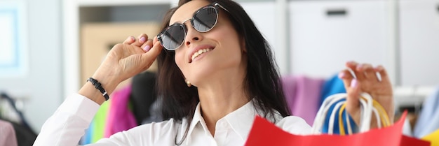 Smiling woman in sunglasses with shopping bags