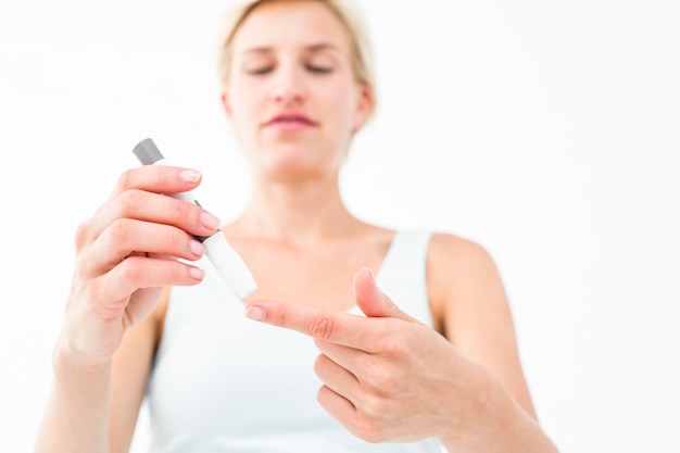 Smiling woman testing her blood glucose level 