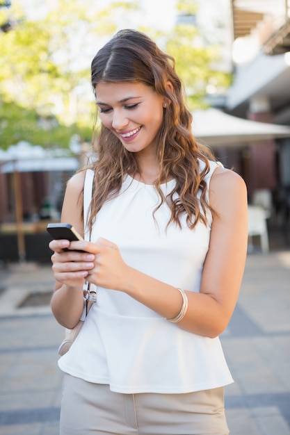 Smiling woman using her smartphone