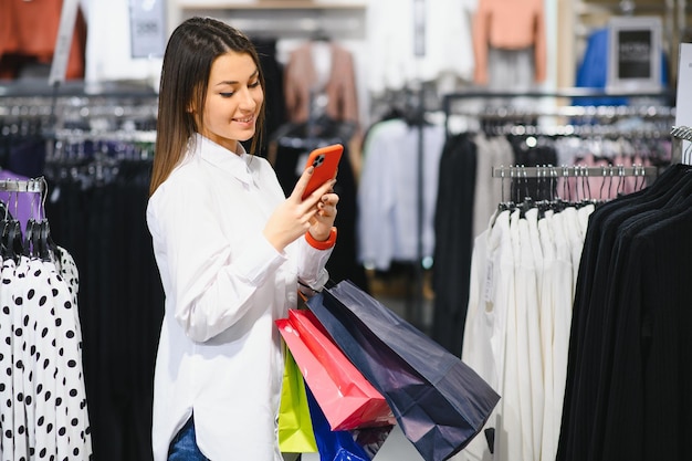 Smiling woman using smartphone at a boutique