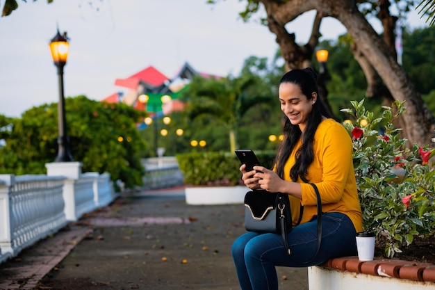 smiling woman watching her cell phone sitting