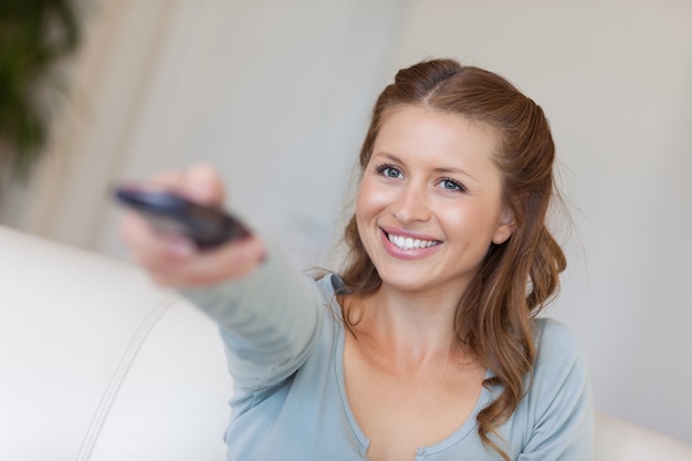 Smiling woman watching tv on her couch