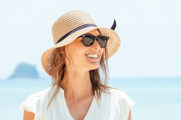 Smiling woman in white dress standing on beach