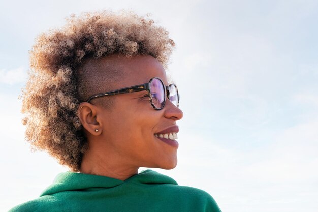 Smiling woman with afro hair looking to the side