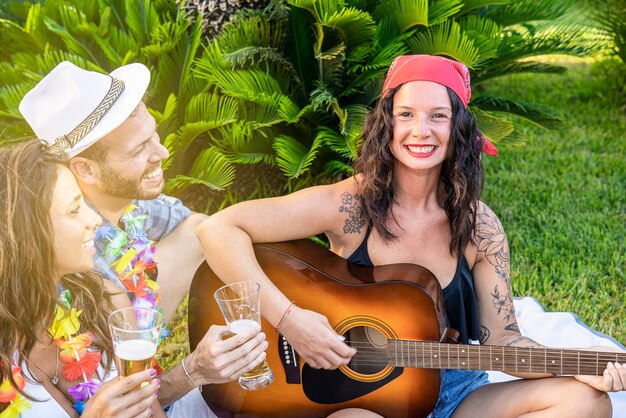 Smiling woman with friends at a garden party playing guitar