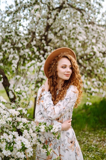 Smiling woman with hat in spring park The concept of relax travel freedom