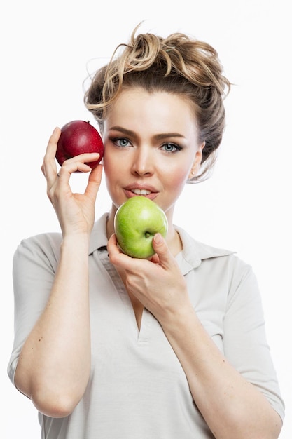 Smiling woman with red and green apples in her hands Beautiful blonde in a gray tshirt Healthy plant food and vitamins White background Vertical