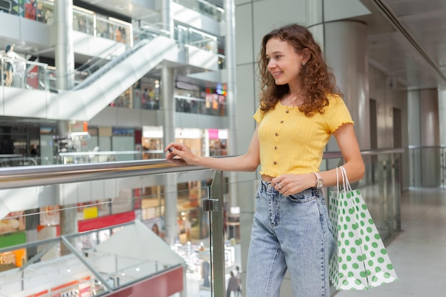 Smiling woman with shopping bags at the shopping mall