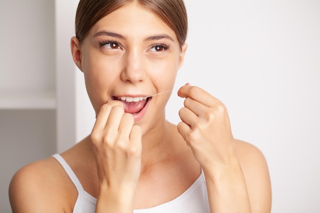 Smiling women use dental floss white healthy teeth.