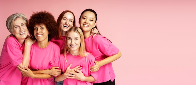 Smiling women with pink ribbon isolated on background copy space Breast cancer awareness month