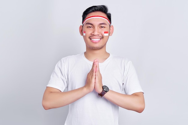 Smiling young Asian man greeting to celebrate Indonesia independence day on August 17 isolated on white background