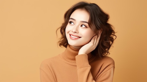 smiling young asian woman in beige sweater on beige background