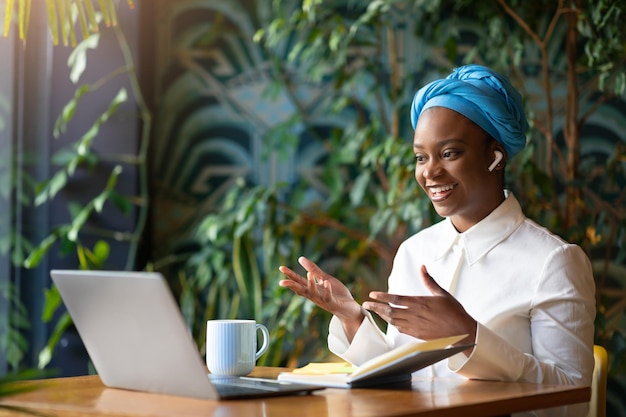 Smiling young black woman employee have online meeting with colleagues