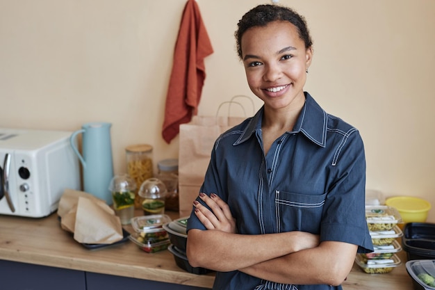 Photo smiling young black woman standing in kitchen