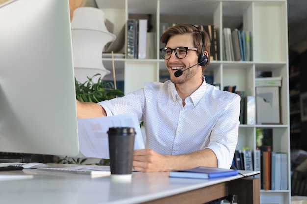 Smiling young business man having video call in office.