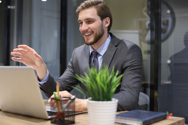 Smiling young business man having video call in office.