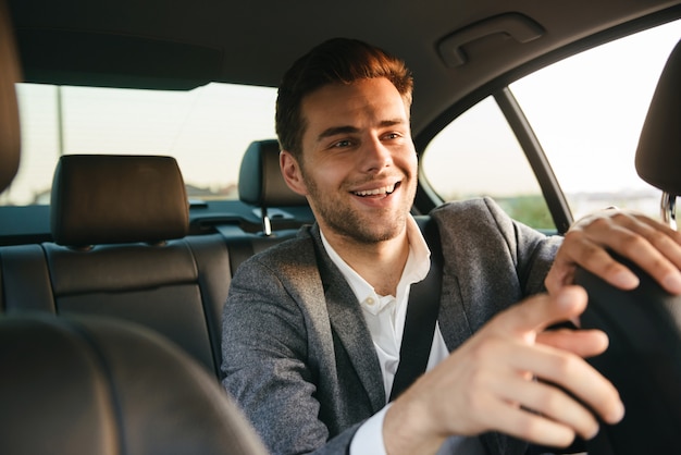 Photo smiling young business man passenger showing taxi driver