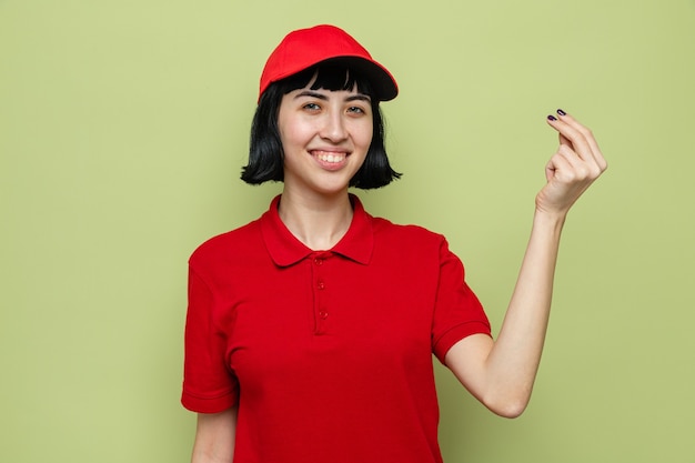 Smiling young caucasian delivery girl pretending to hold something