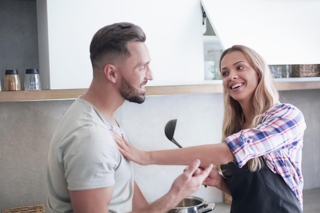 Smiling young couple cooking food in the kitchen