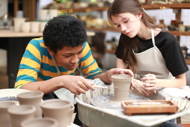 Smiling young couple in pottery workshop