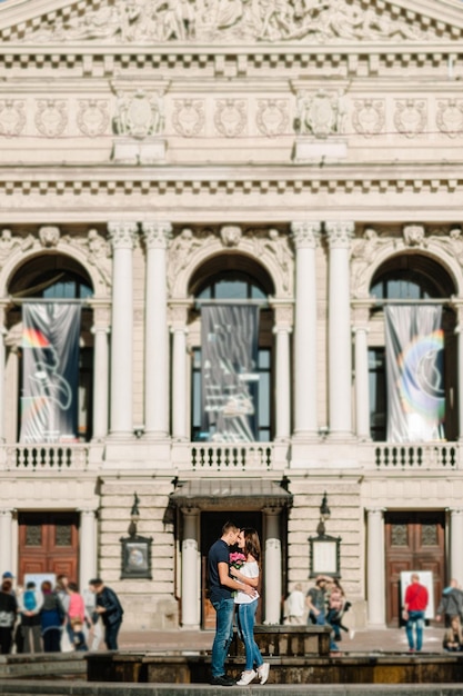 Smiling Young couple with a bouquet of flowers in love hug each other in love outdoors Love and tenderness dating romance Lifestyle concept