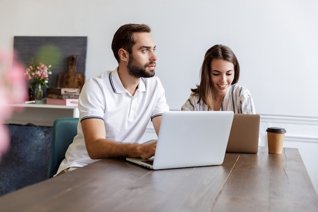 Smiling young couple working on a project while sitting at the desk at home