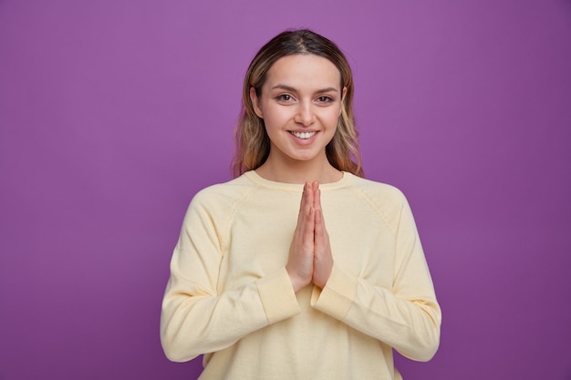 Smiling young girl doing namaste gesture 