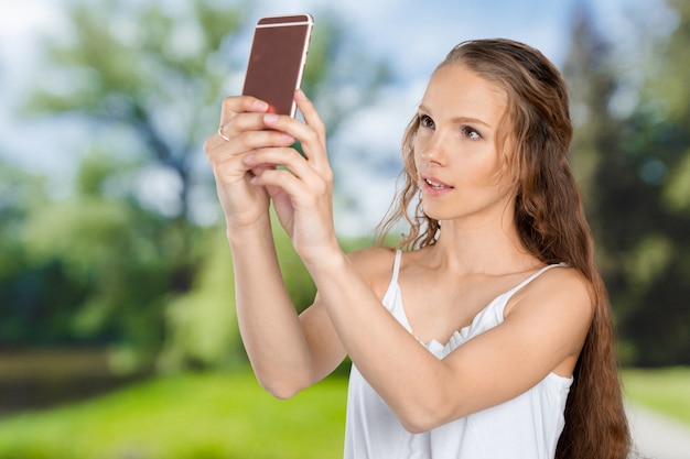 Smiling young girl making selfie photo on smartphone