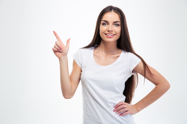 Smiling young girl pointing finger up