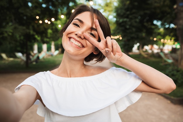 Smiling young girl showing peace gesture