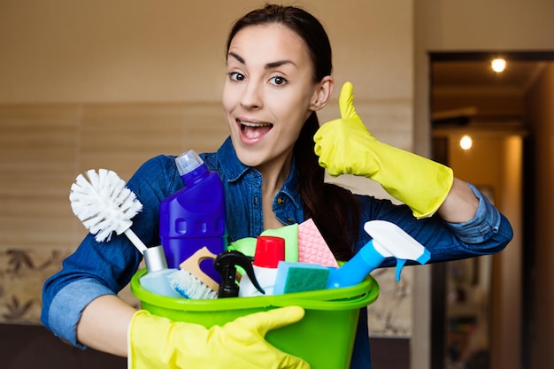 Smiling young girl with the equipment for cleaning