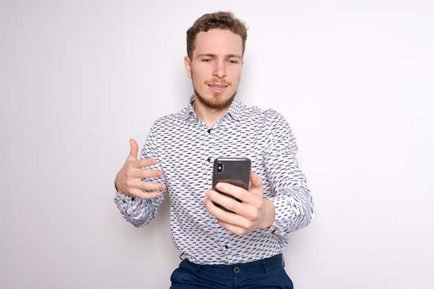 Smiling young handsome caucasian man using a smartphone to contact family