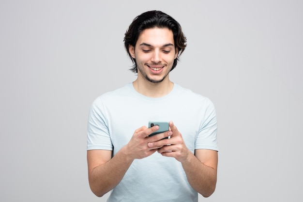 smiling young handsome man using his mobile phone isolated on white background