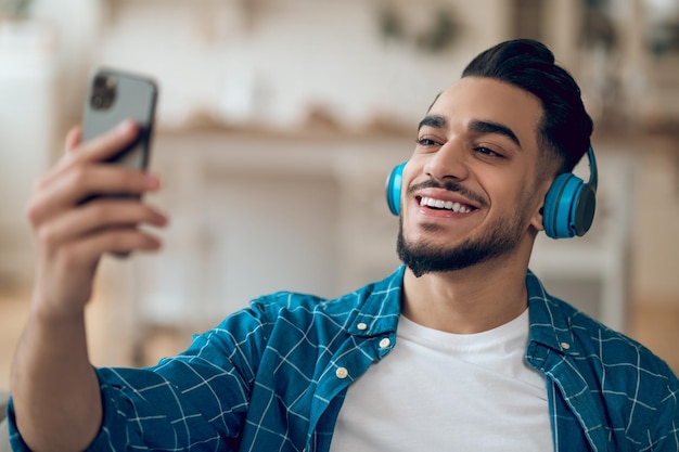 Smiling young man in a blue tshirt and with headphones