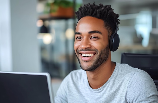 Smiling young man with headphones using computer in a modern office setting