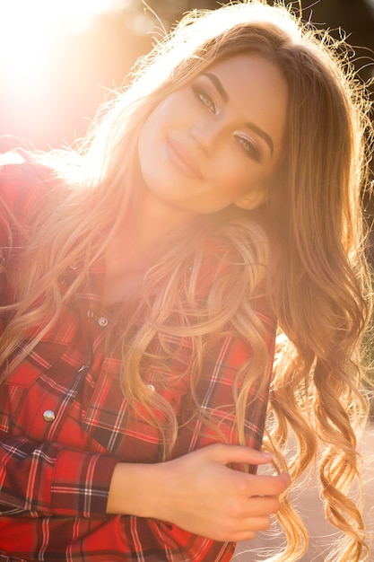 Smiling young model posing at the street in a sunny day in summer