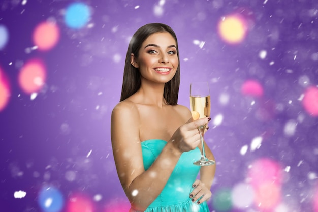 Smiling young model with glass of champagne indoors