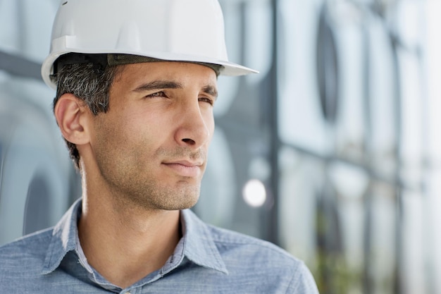 Smiling young unshaven business man in light shirt protective construction helmet