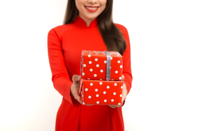 Smiling young woman in ao dai  giving two giftboxs