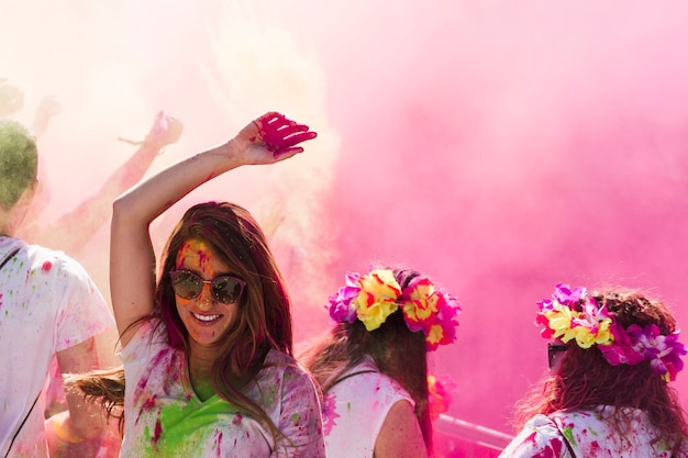 Smiling young woman dancing in the holi color