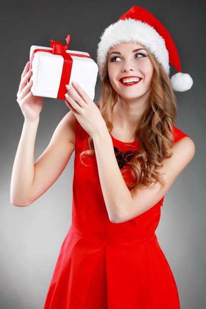 Smiling young woman holding christmas gifts