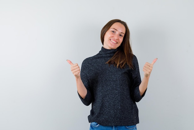 Smiling young woman holding an OK hand sign on white background