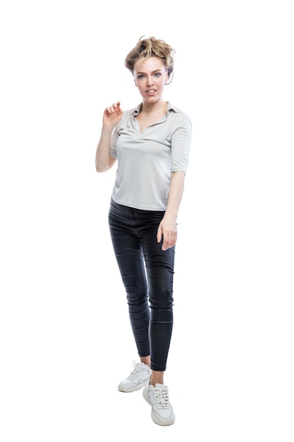 Smiling young woman is standing Beautiful blonde in black leggings a gray tshirt and white sneakers Positivity and happiness Full height Isolated on white background Vertical