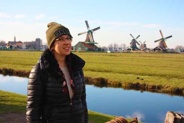 Photo smiling young woman standing on field against sky